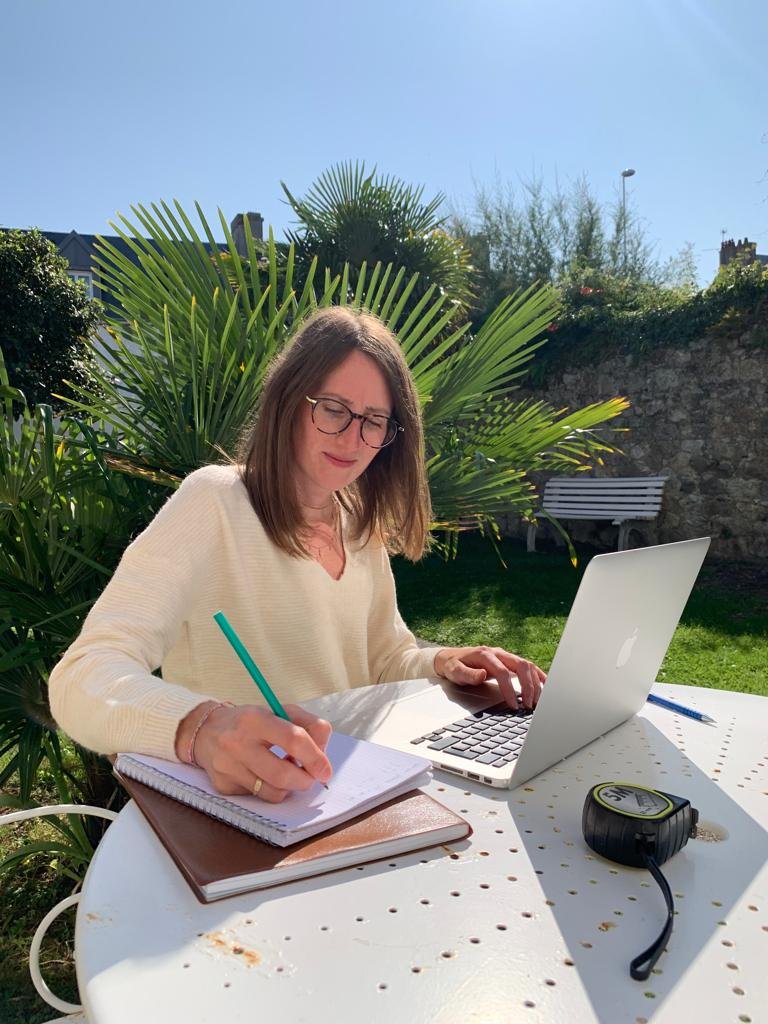 Image pour illustrer mon histoire et mes valeurs. Clémence Coletti en train de travailler sur une table en extérieur.